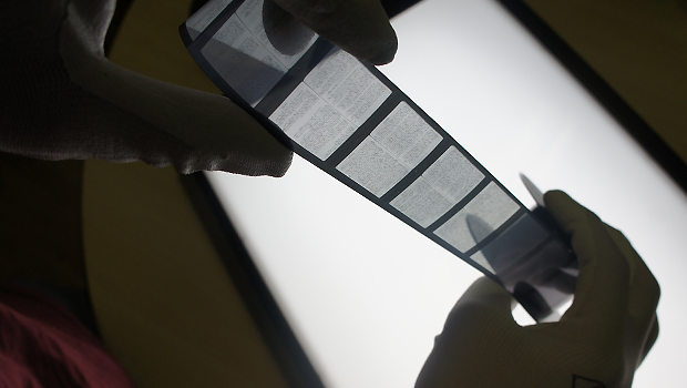 Imaging technician checking microfilm before digitising